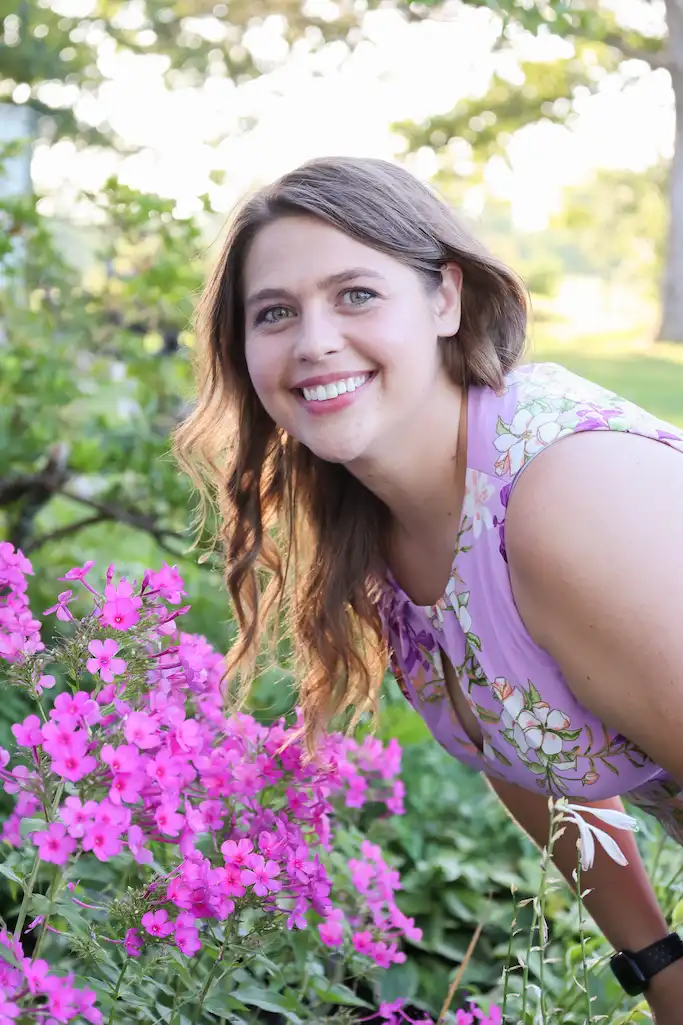 Smiling woman among pink flowers.